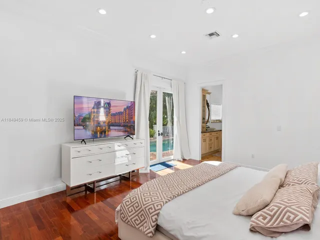 a bedroom with a bed and a flat screen tv