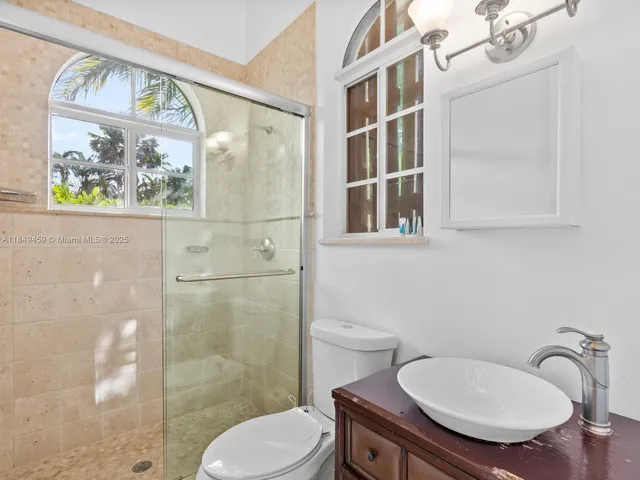 a bathroom with a toilet a sink and mirror