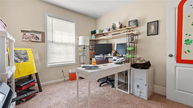a view of a workspace with furniture and a window