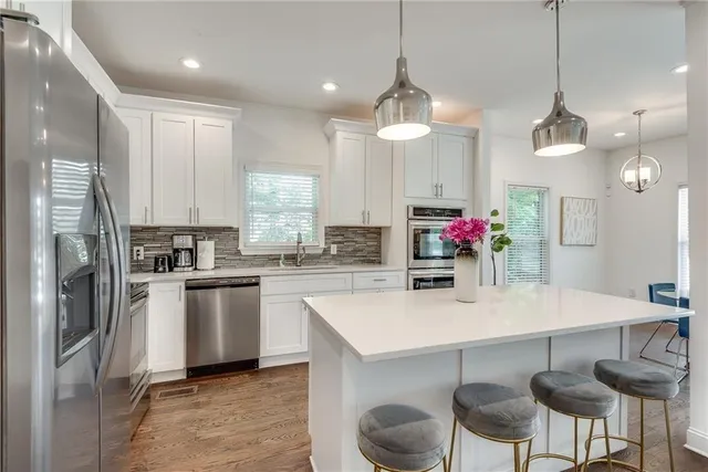 a kitchen with kitchen island granite countertop a sink and refrigerator