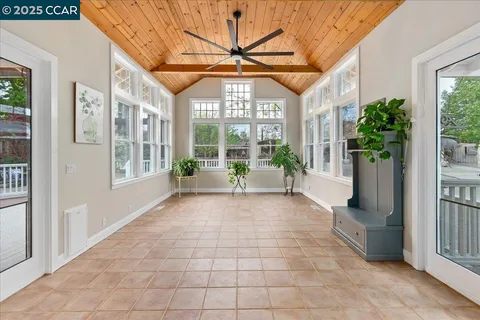 a view of a porch with a floor to ceiling window and potted plants
