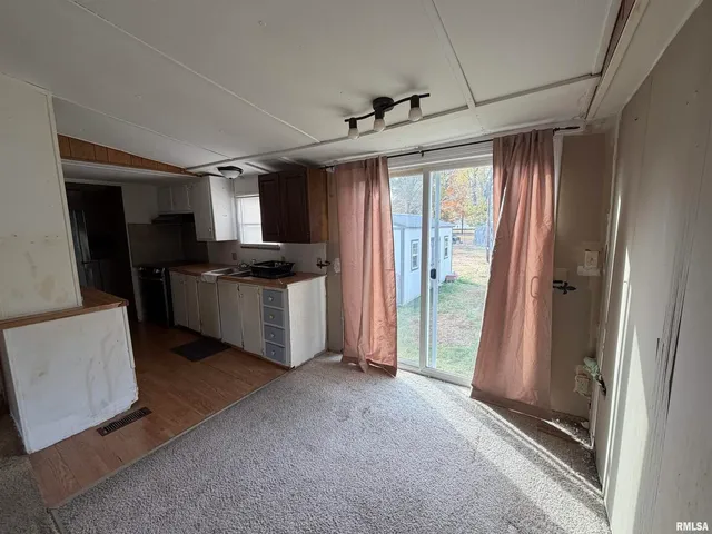 a kitchen with stainless steel appliances granite countertop a refrigerator a sink a stove and white cabinets