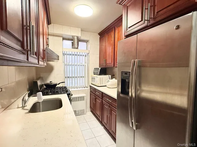 a kitchen with a sink refrigerator and cabinets