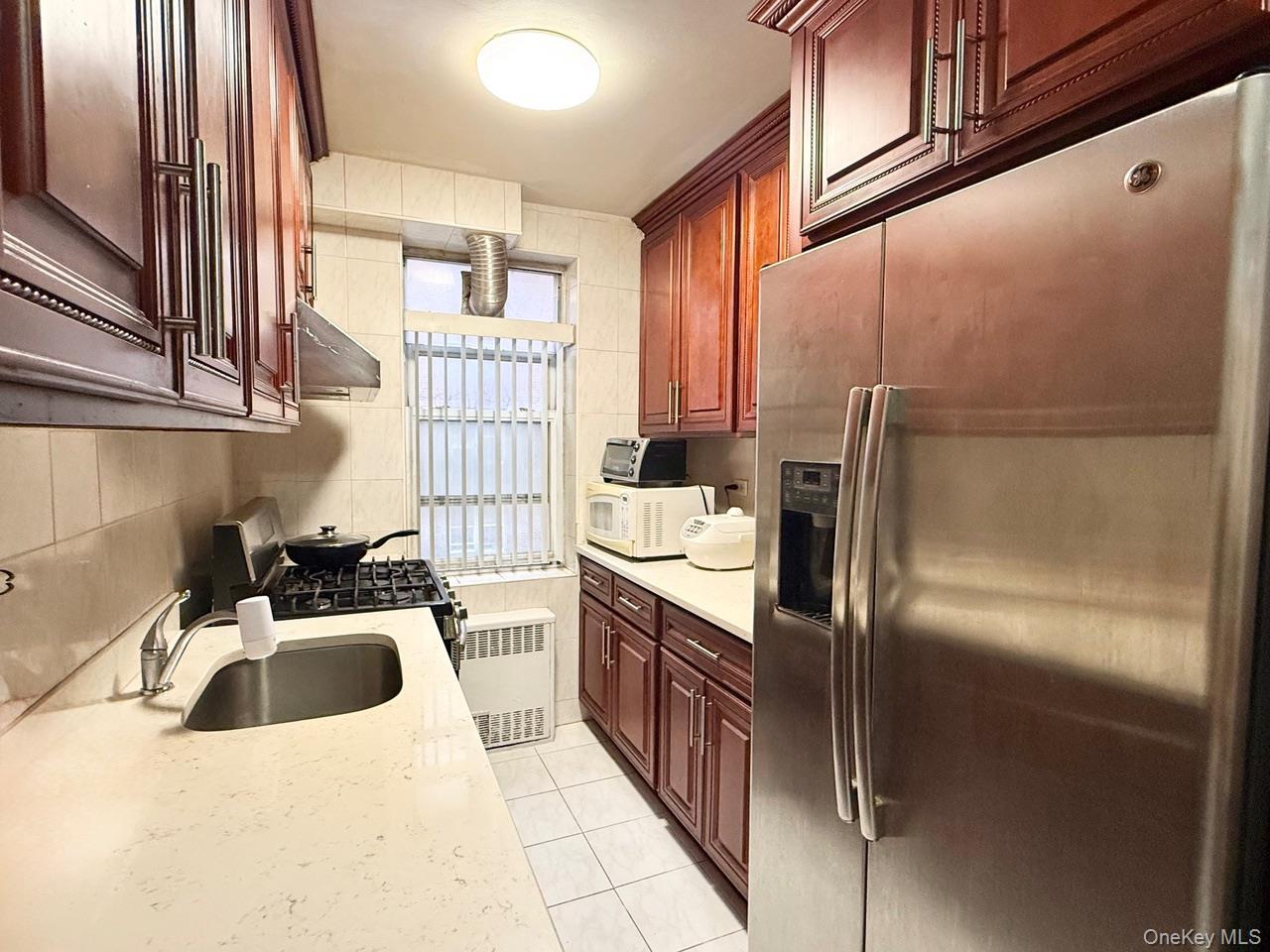 43-35 Union Street, Unit 2G Queens, NY 11355 - Photo 8 of 15 a kitchen with a sink refrigerator and cabinets