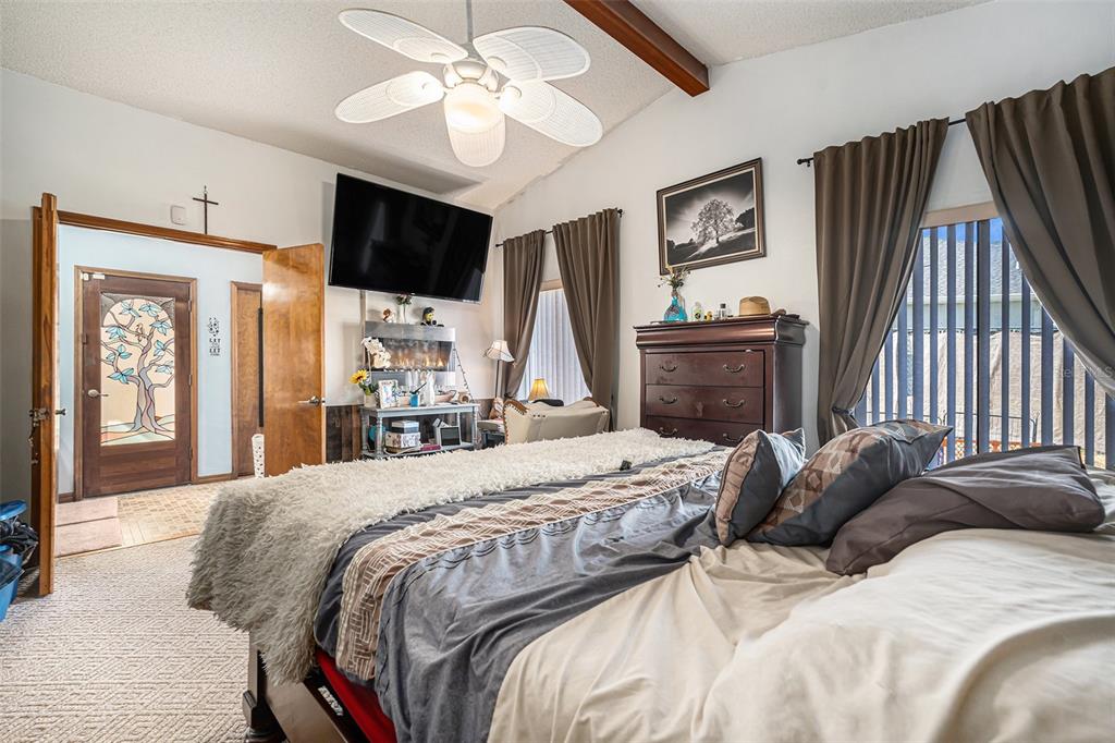 8212 Delaware Drive Weeki Wachee, FL 34607 - Photo 18 of 33 a bedroom with a large bed a flat tv screen and dresser