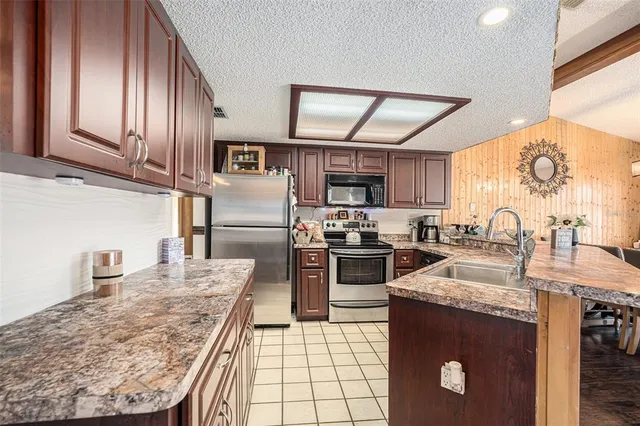 a kitchen with granite countertop stainless steel appliances and wooden cabinets