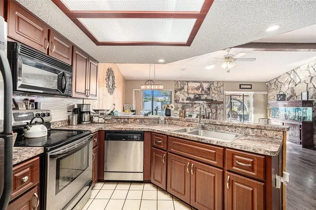 a kitchen with stainless steel appliances granite countertop a sink stove and cabinets