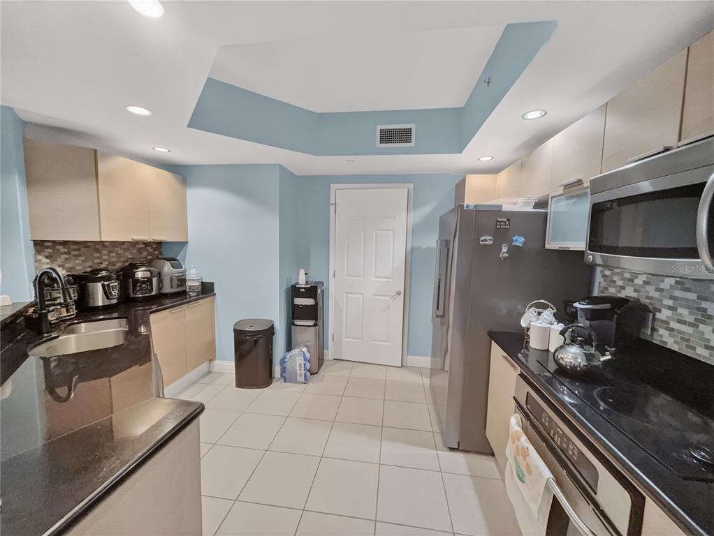 231 Riverside Drive, Unit 2081 Holly Hill, FL 32117 - Photo 7 of 38 a kitchen with a refrigerator and a stove top oven