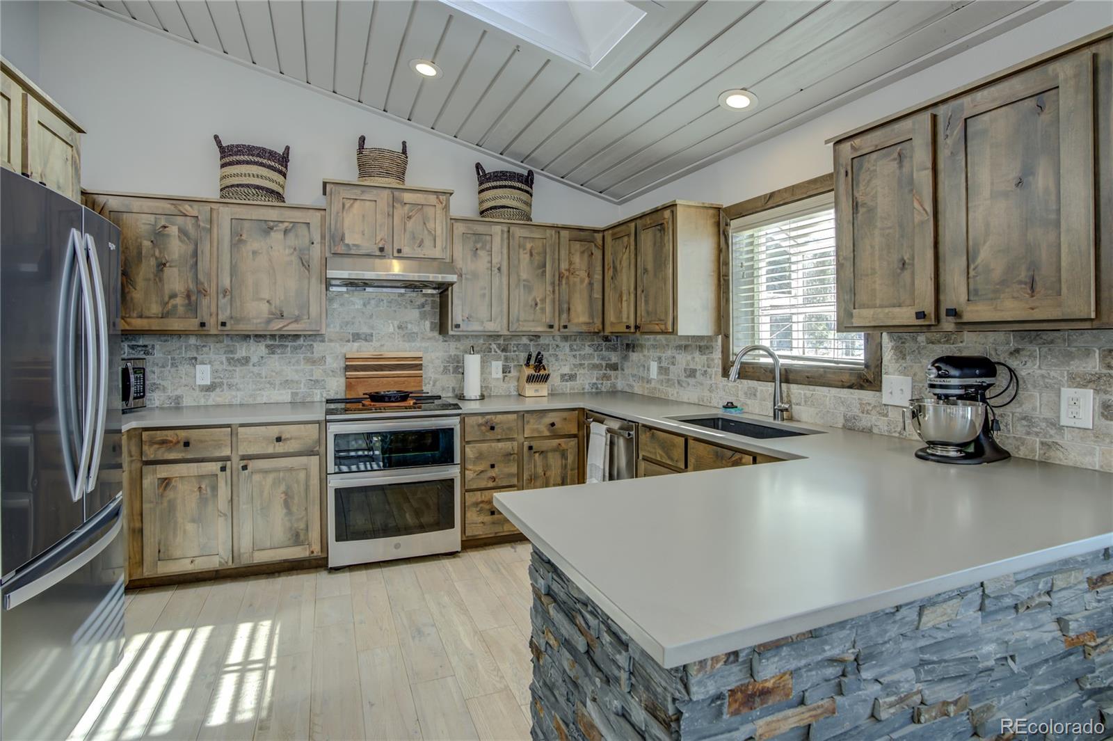 19273 Silver Ranch Road Conifer, CO 80433 - Photo 15 of 37 a kitchen with stainless steel appliances granite countertop a stove sink and cabinets