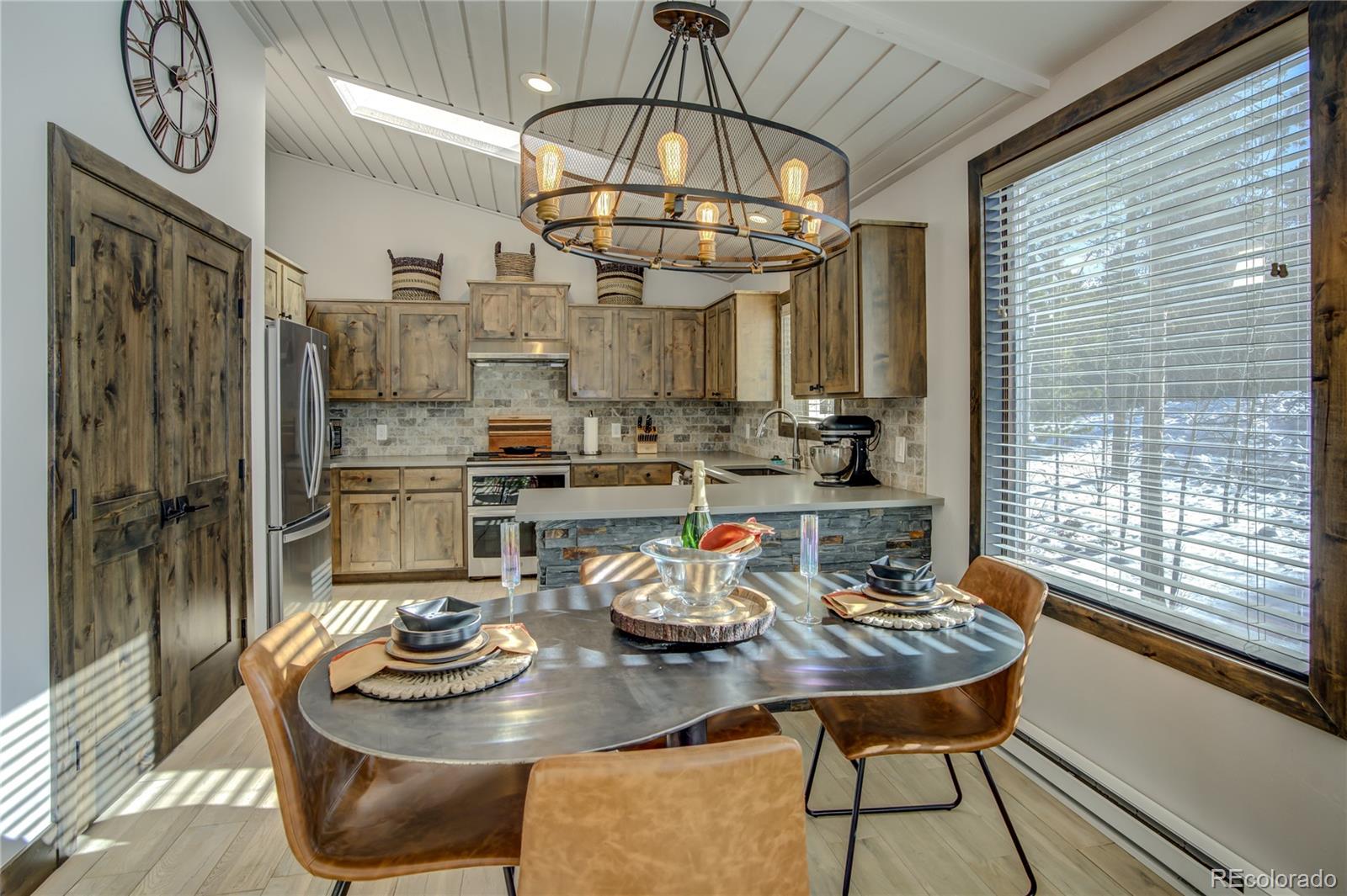 19273 Silver Ranch Road Conifer, CO 80433 - Photo 16 of 37 a dining room with furniture a chandelier and wooden floor