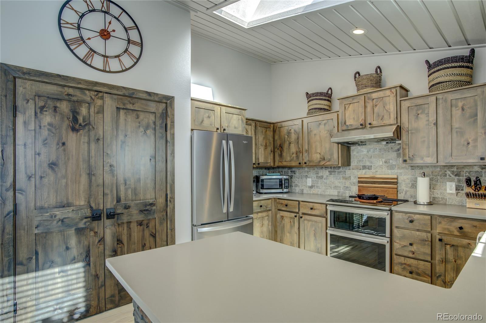 19273 Silver Ranch Road Conifer, CO 80433 - Photo 17 of 37 a kitchen with stainless steel appliances granite countertop a sink a stove and cabinets