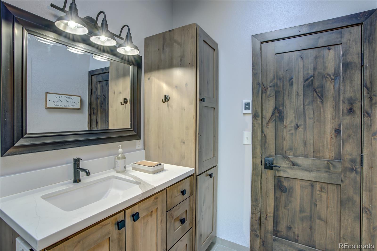 19273 Silver Ranch Road Conifer, CO 80433 - Photo 19 of 37 a bathroom with a sink vanity granite shower and a mirror