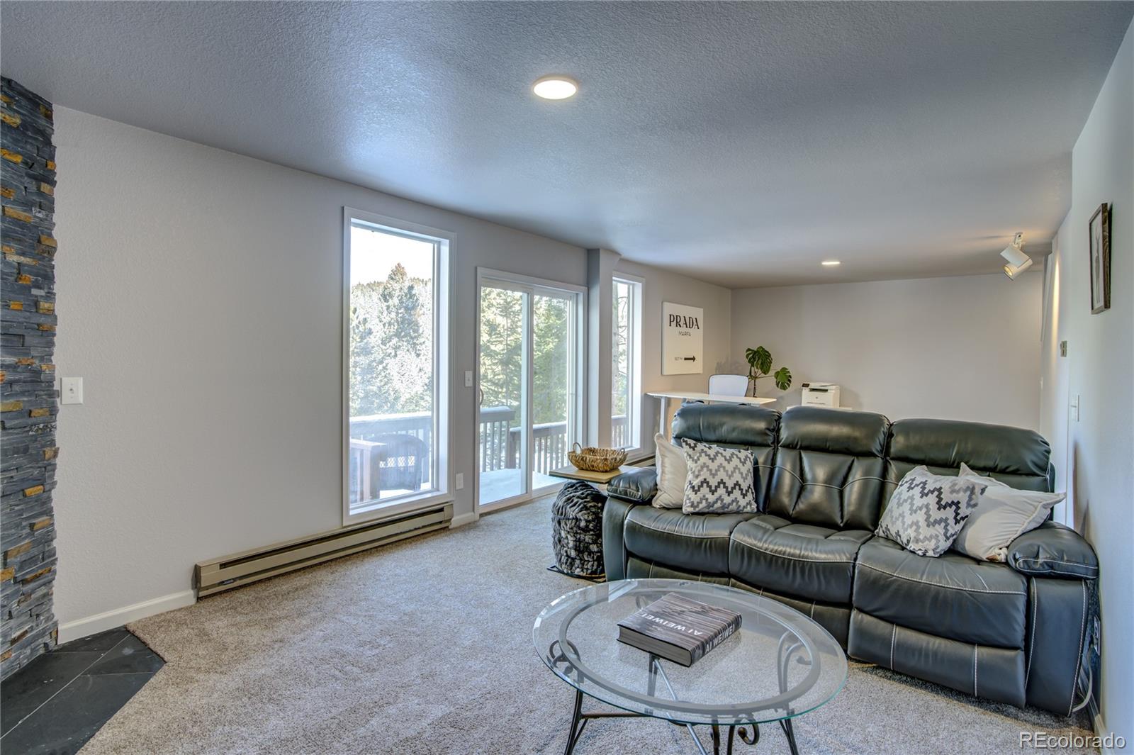 19273 Silver Ranch Road Conifer, CO 80433 - Photo 32 of 37 a living room with furniture and a flat screen tv