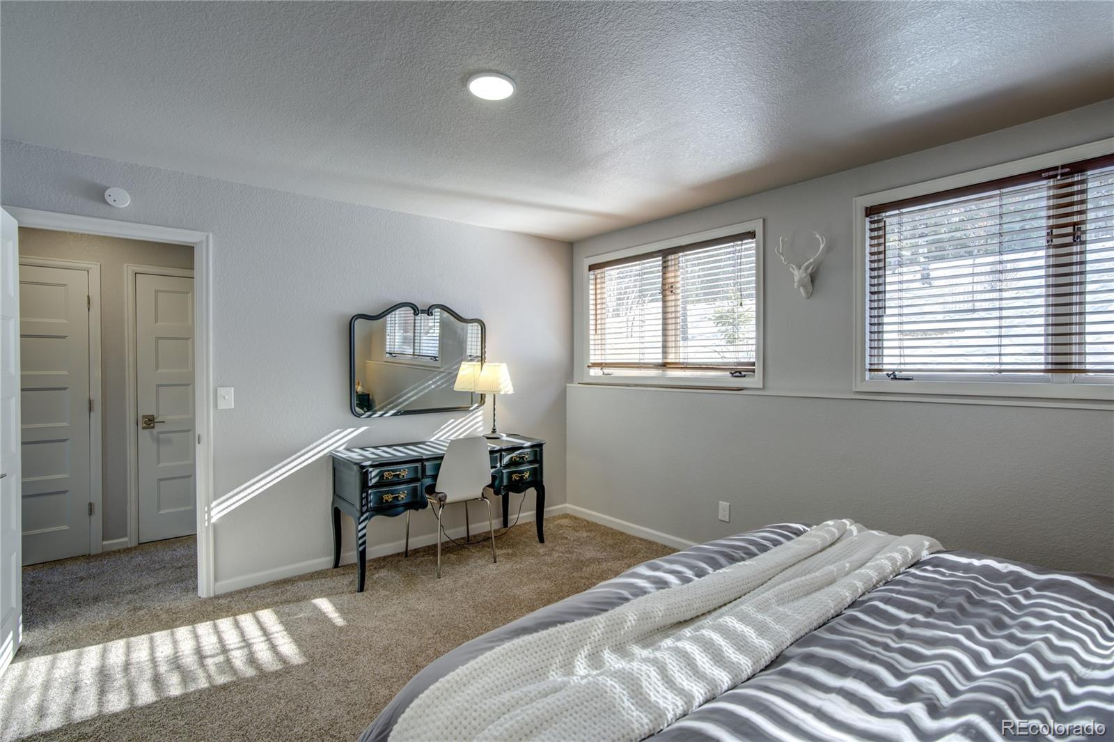 19273 Silver Ranch Road Conifer, CO 80433 - Photo 34 of 37 a bedroom with a bed and wooden floor