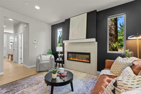 a living room with furniture dining table a rug and a large window