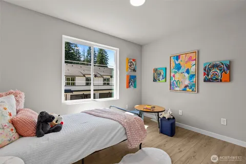 a bedroom with a bed and wooden floor