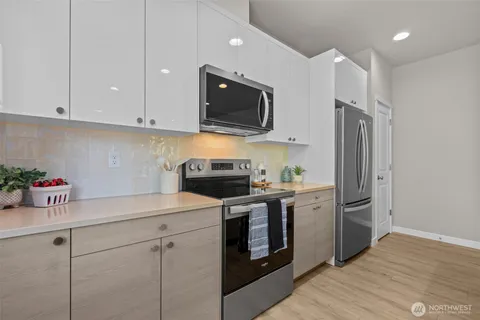 a kitchen with a refrigerator a table and chairs