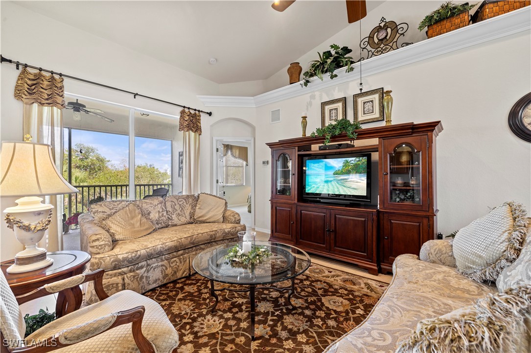 14941 Reflection Key Circle, Unit 621 Fort Myers, FL 33907 - Photo 13 of 42 a living room with furniture a flat screen tv and a floor to ceiling window
