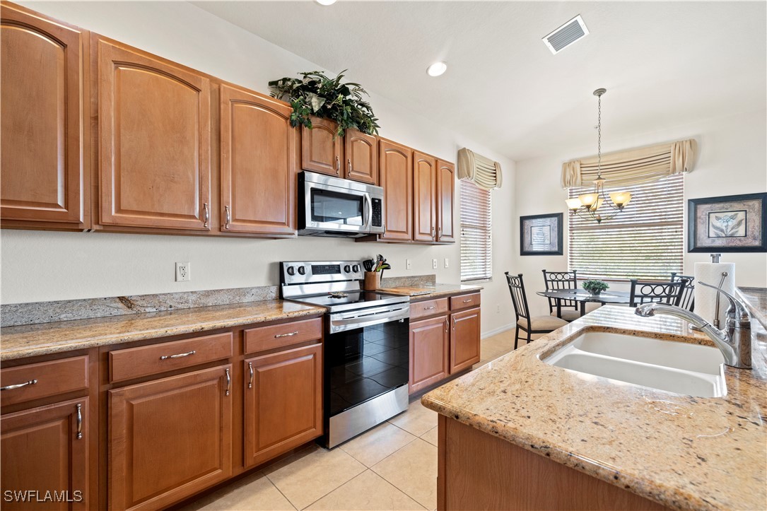 14941 Reflection Key Circle, Unit 621 Fort Myers, FL 33907 - Photo 15 of 42 a kitchen with kitchen island granite countertop a sink counter top space appliances and cabinets