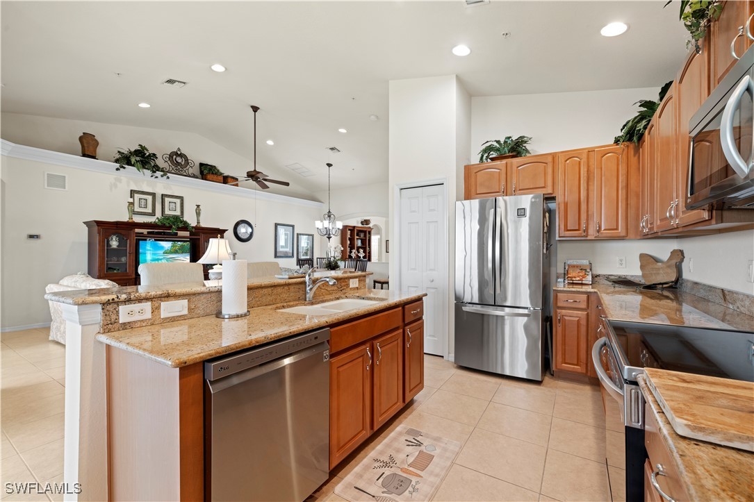 14941 Reflection Key Circle, Unit 621 Fort Myers, FL 33907 - Photo 16 of 42 a kitchen with stainless steel appliances granite countertop a sink refrigerator and microwave