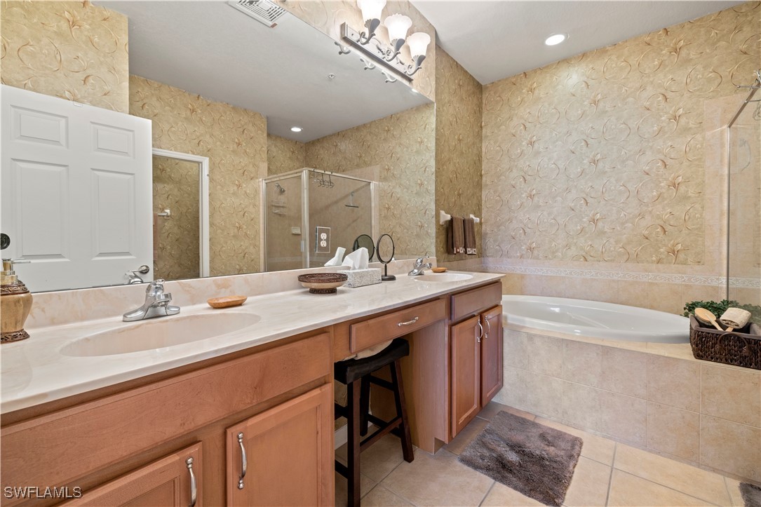14941 Reflection Key Circle, Unit 621 Fort Myers, FL 33907 - Photo 20 of 42 a bathroom with a double vanity sink a mirror and a bathtub