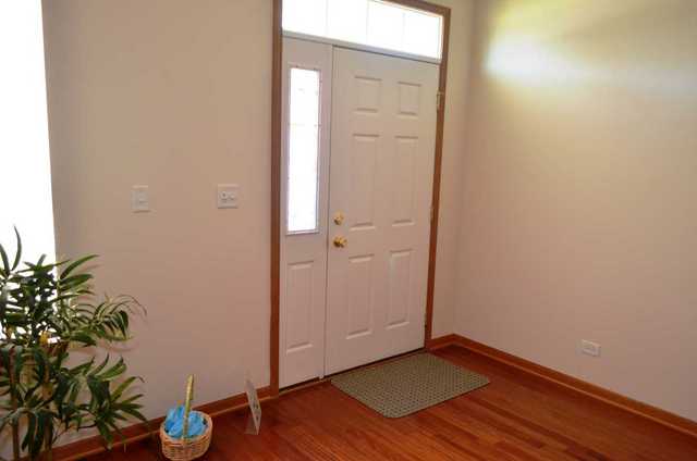 2548 Congress Avenue Aurora, IL 60503 - Photo 2 of 22 an empty room with wooden floor and a potted plant
