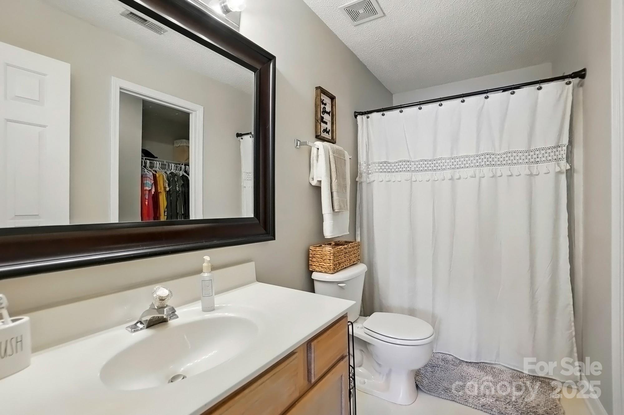 820 Settlement Street Clover, SC 29710 - Photo 17 of 29 a bathroom with a sink a toilet and shower curtain