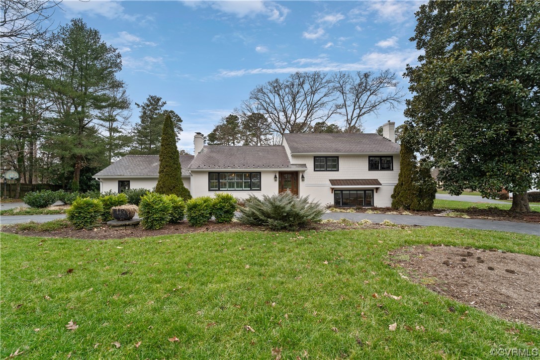 a front view of a house with a yard and trees