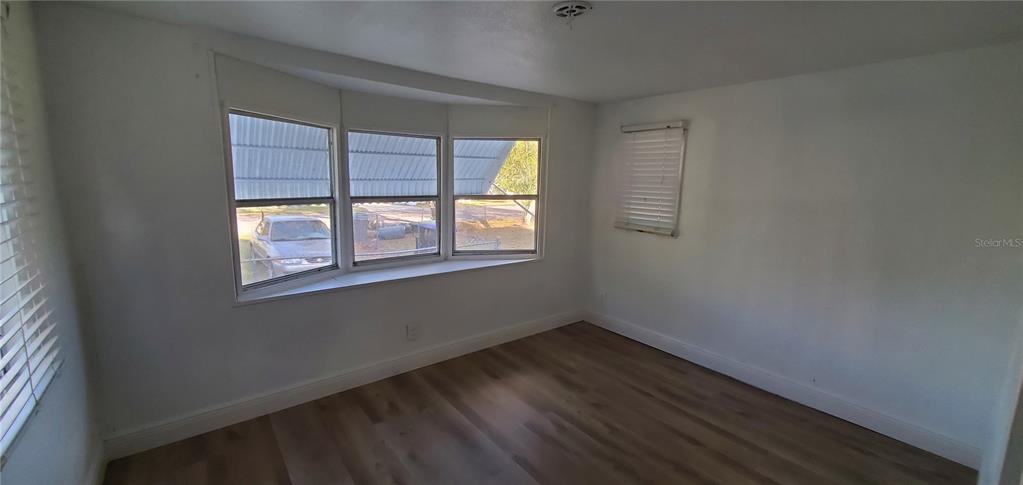 4305 Tony Street Orlando, FL 32808 - Photo 12 of 23 a view of an empty room with wooden floor and a window