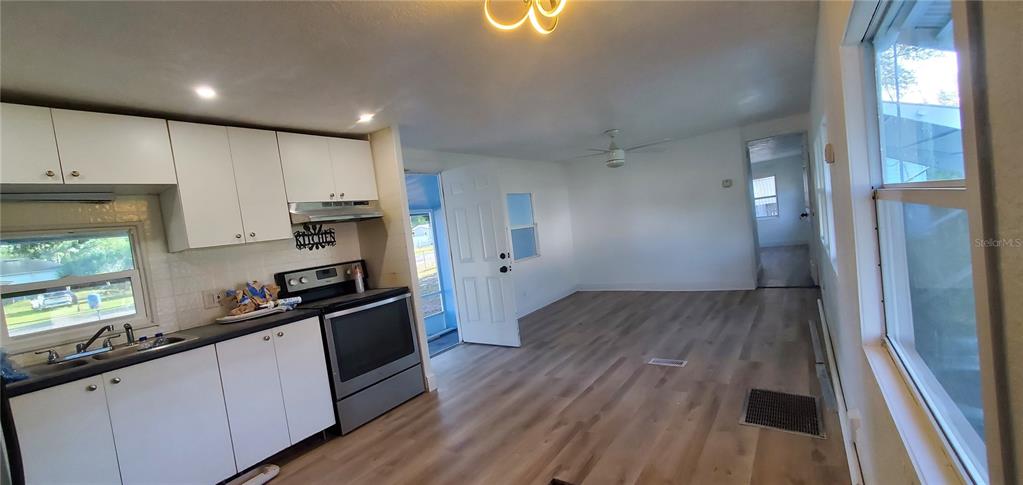 4305 Tony Street Orlando, FL 32808 - Photo 6 of 23 a kitchen with kitchen island wooden floors appliances and cabinets