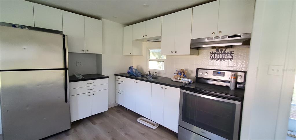 4305 Tony Street Orlando, FL 32808 - Photo 7 of 23 a kitchen with stainless steel appliances a refrigerator sink and cabinets