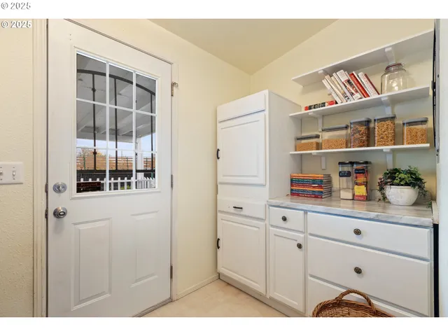 a kitchen with white cabinets and window