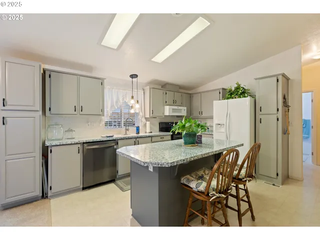 a kitchen with stainless steel appliances granite countertop kitchen island a table and chairs in it