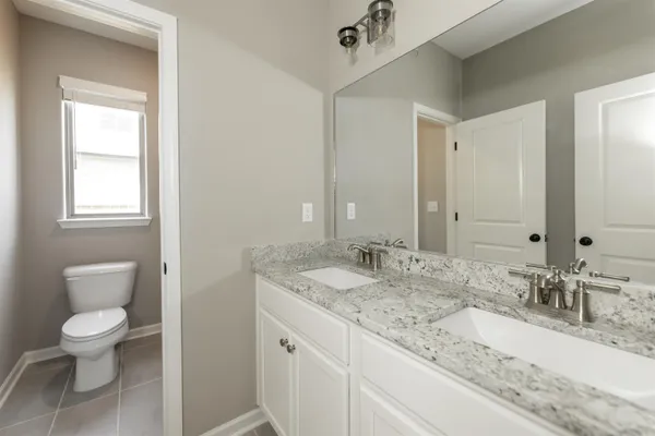 a bathroom with a granite countertop sink a toilet and a mirror