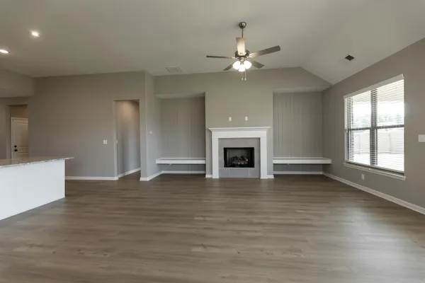 a view of an empty room with window and fire place