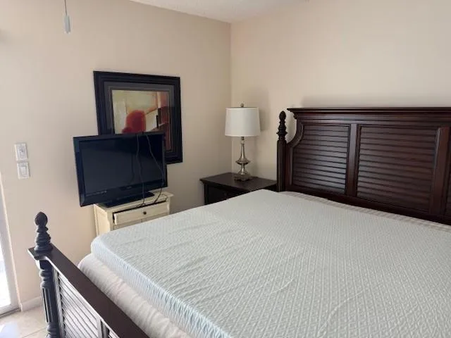 a bedroom with a bed and a flat screen tv