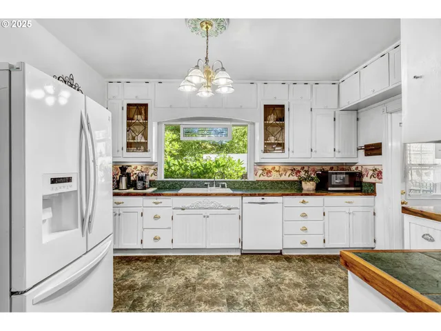 a kitchen with granite countertop white cabinets and white appliances