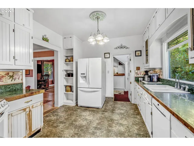a kitchen with refrigerator cabinets and large window