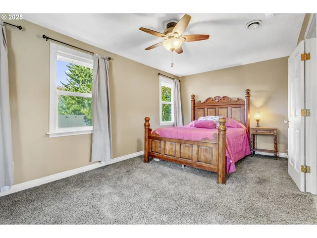 a bedroom with a bed and a ceiling fan