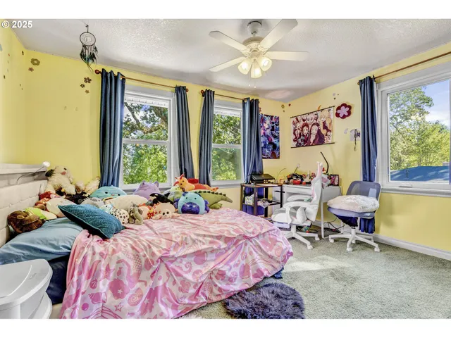 a bedroom with a bed and large windows