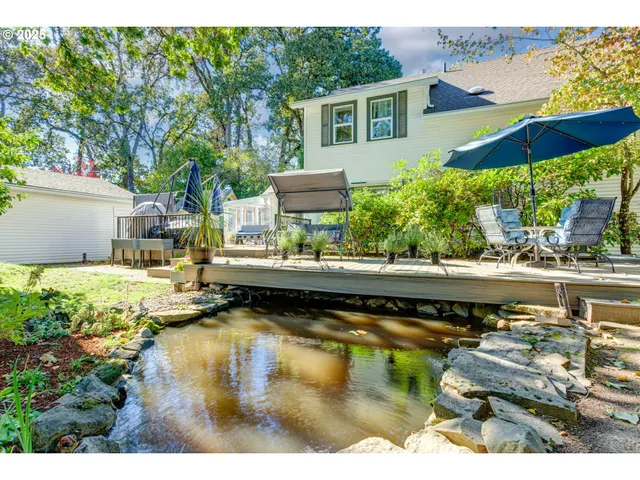 a view of swimming pool with lawn chairs and plants