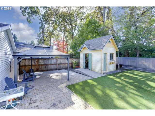 a view of a house with backyard and sitting area