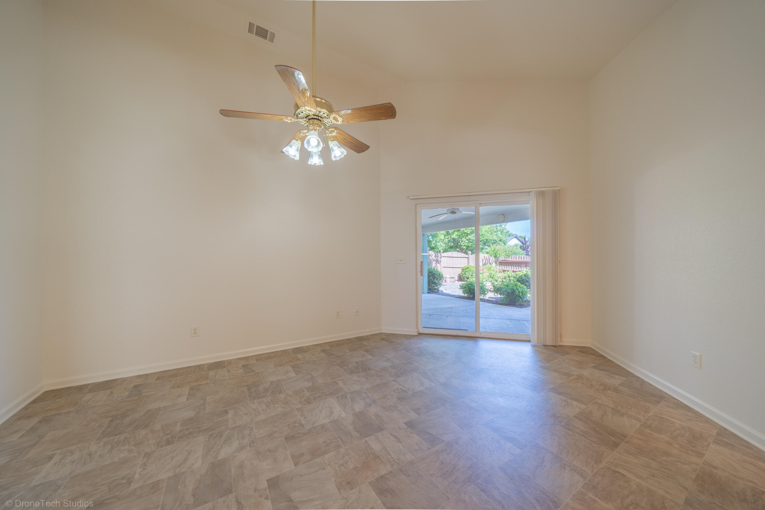 1764 Capistrano Walk Redding, CA 96003 - Photo 15 of 34 an empty room with wooden floor chandelier fan and windows