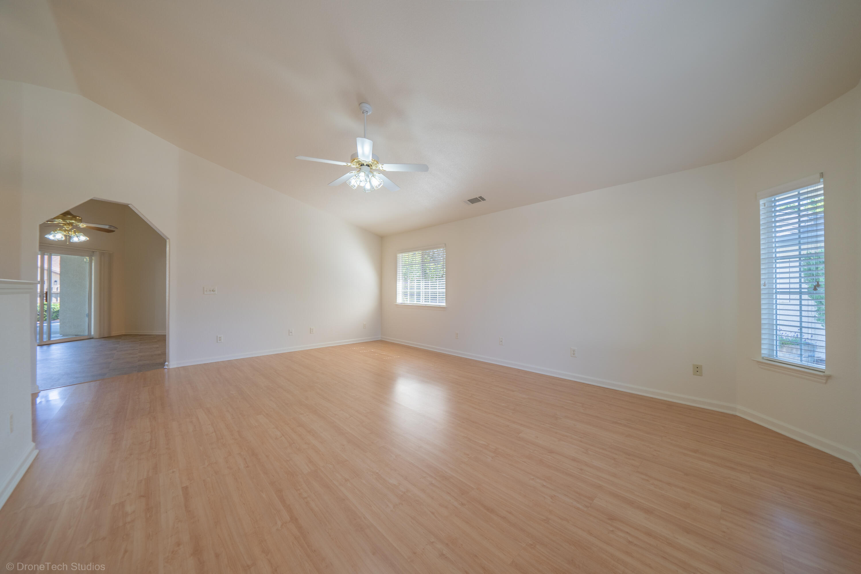 1764 Capistrano Walk Redding, CA 96003 - Photo 6 of 34 an empty room with wooden floor chandelier fan and windows