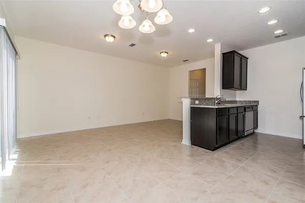 a view of kitchen with kitchen island stainless steel appliances a sink cabinets and stove top oven
