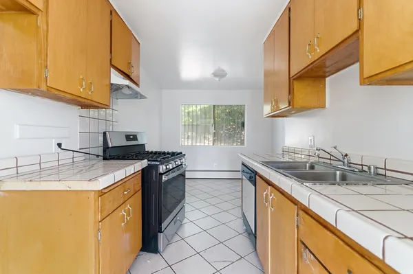 a kitchen with stainless steel appliances granite countertop a sink stove and cabinets
