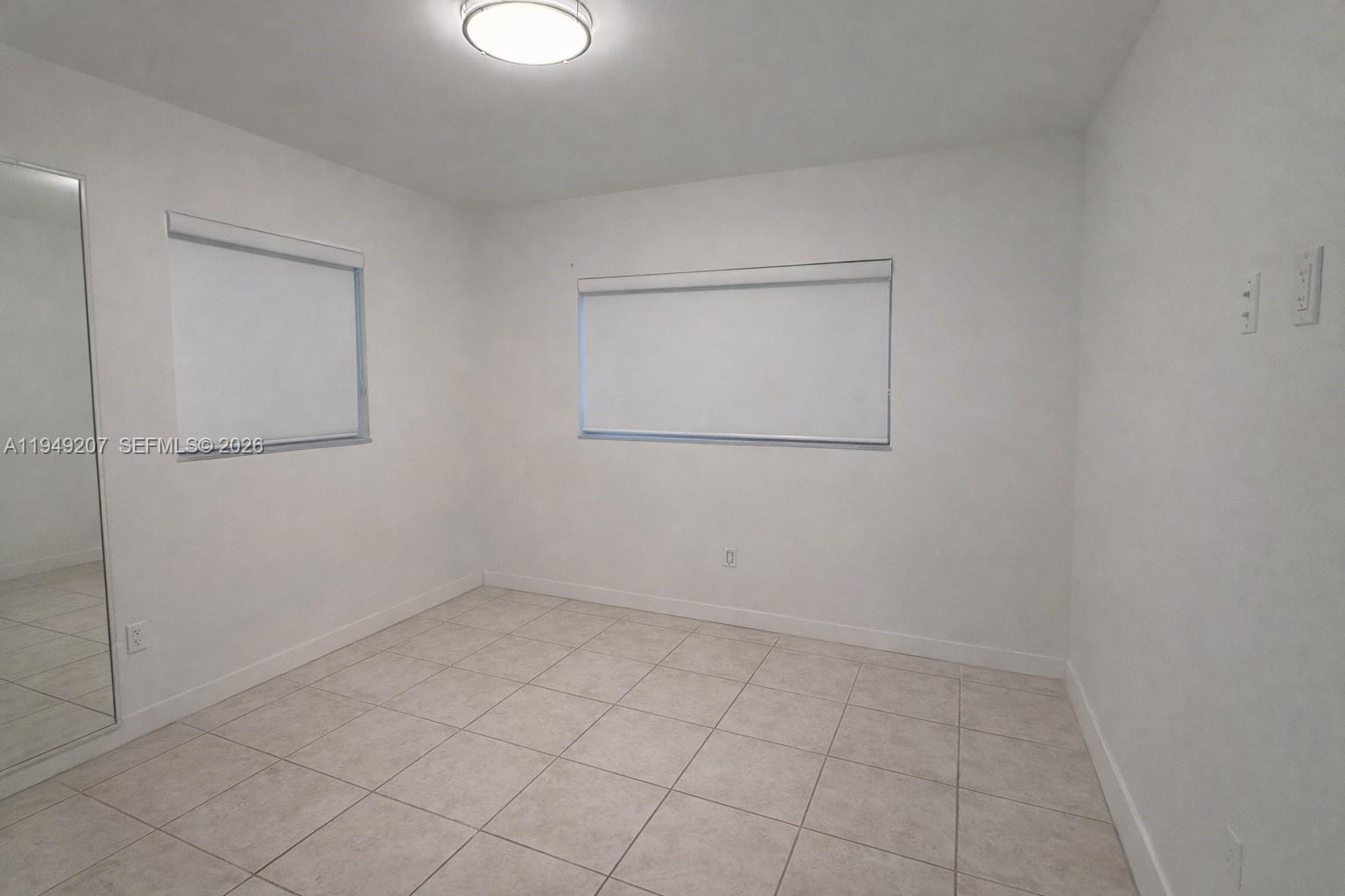 11930 Southwest 187th Terrace Miami, FL 33177 - Photo 7 of 13 an empty room with a mirror