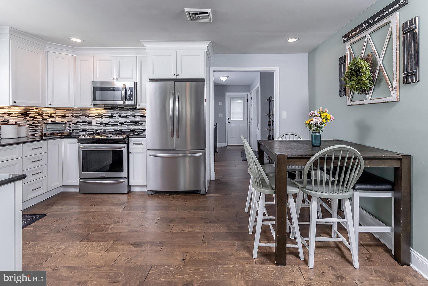 575 Allegheny Road Wenonah, NJ 08090 - Photo 7 of 23 a kitchen with granite countertop a table chairs refrigerator and cabinets