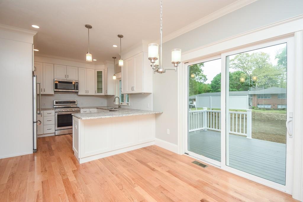 72 Bethany Road Framingham, MA 01702 - Photo 15 of 41 a large kitchen with kitchen island white cabinets and wooden floor