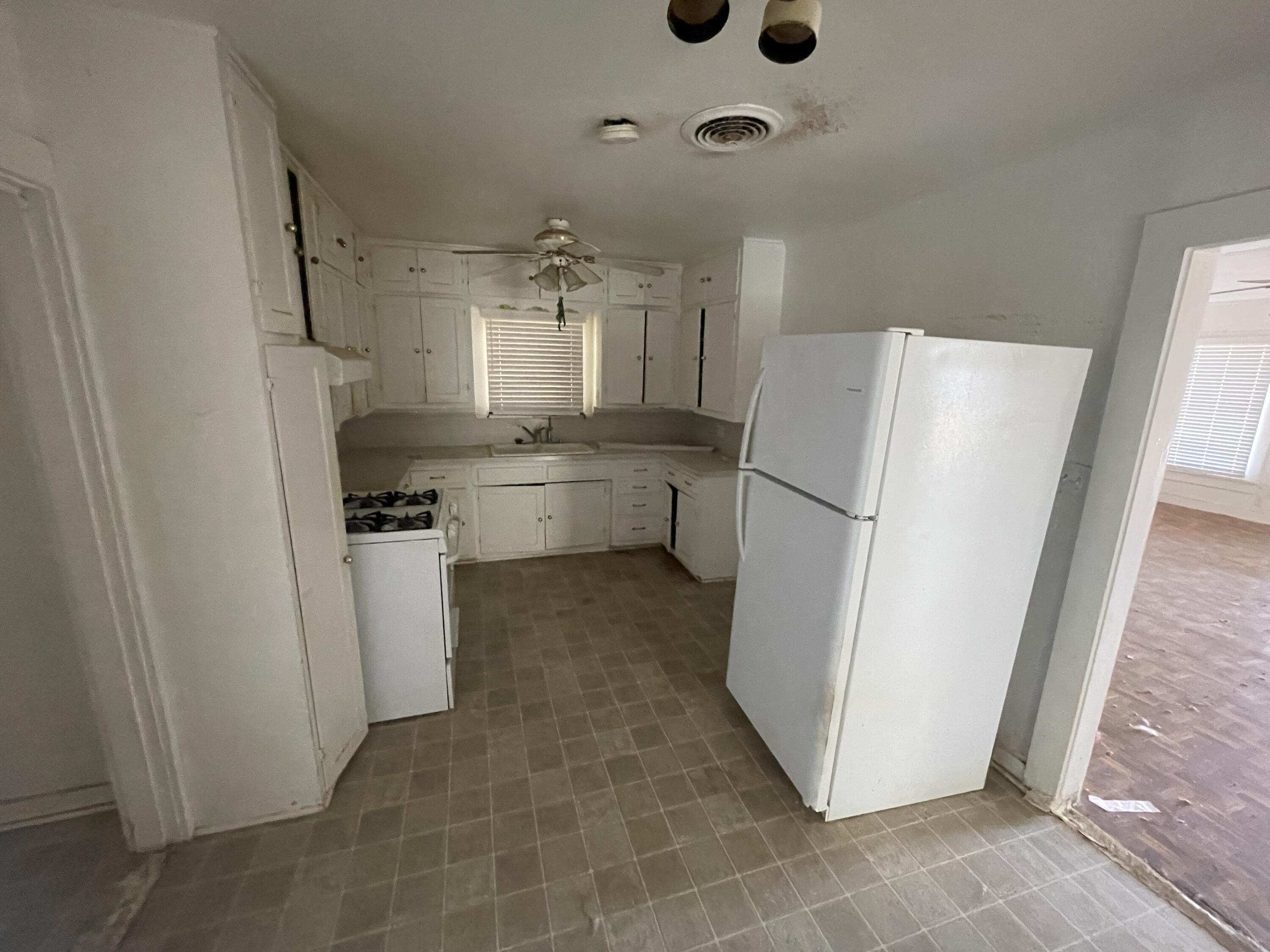101 S Avenue Post, TX 79356 - Photo 9 of 19 a kitchen with a refrigerator a stove top oven and a glass door